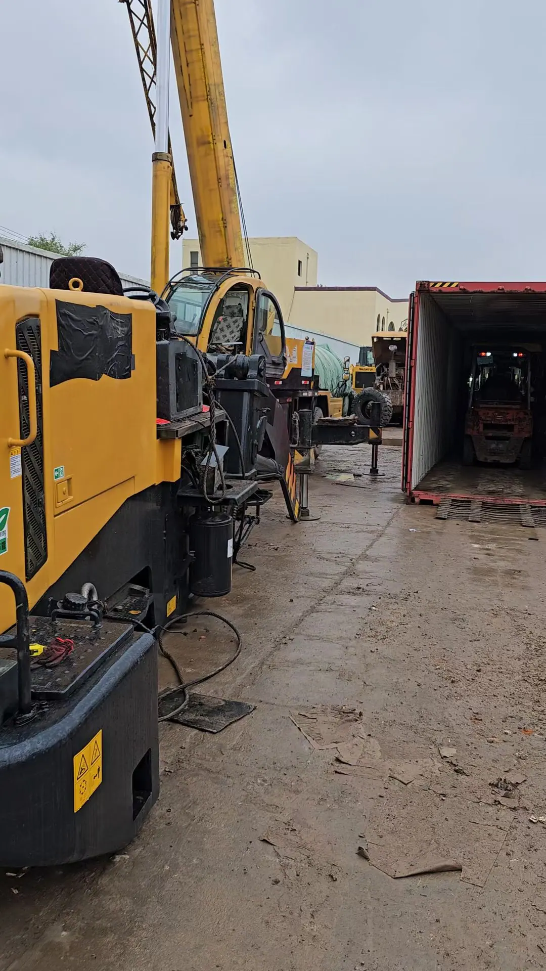 Gantry cranes handling a used excavator at a Chinese port terminal